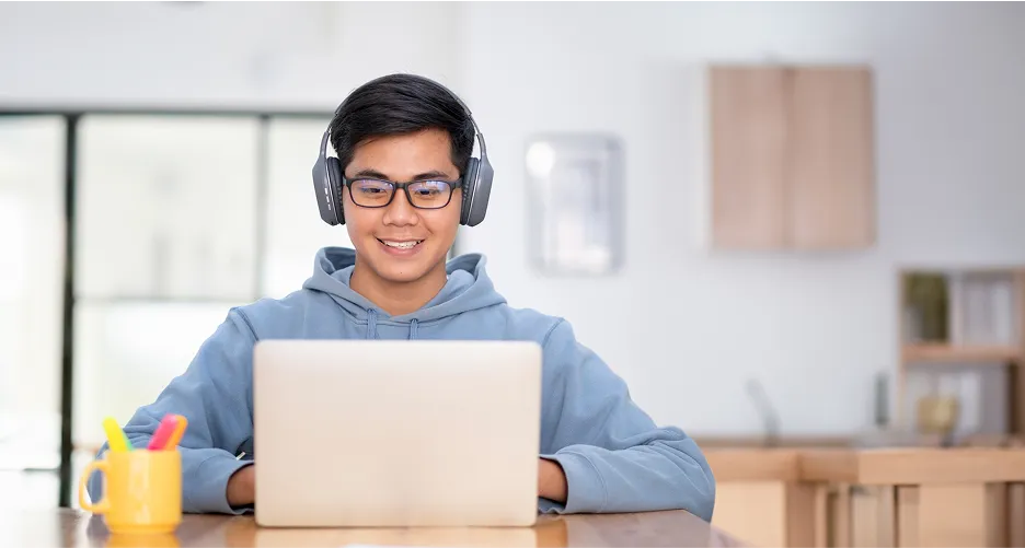 Student learning online with headphones and laptop